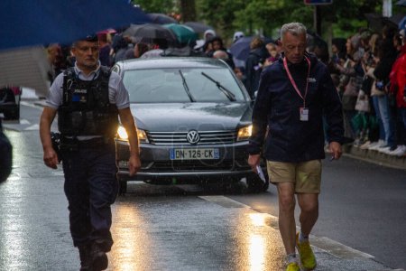 Téléchargez les photos : France, jour, 22 Mai 2024 : Police et organisateur d'événements marchant dans la rue pluvieuse lors d'un événement public - en image libre de droit