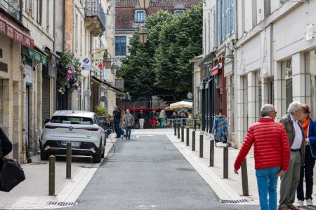 Téléchargez les photos : France, 19 mai 2024 : Des gens marchent dans une rue étroite dans une charmante ville avec de vieux bâtiments et des cafés extérieurs. - en image libre de droit