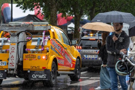 Téléchargez les photos : France, 22, Mai, 2024 : Camion de remorquage et voiture de police dans la scène urbaine pluvieuse - en image libre de droit