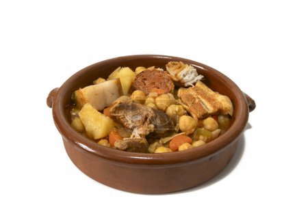 Foto de Un tazón de barro con un guiso de garbanzo andaluz, aislado sobre un fondo blanco, de cerca. Concepto de comida española. - Imagen libre de derechos