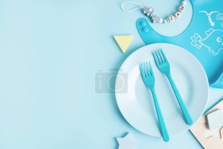 Photo for Blue plate with blue cutlery on blue background. Baby food concept. - Royalty Free Image