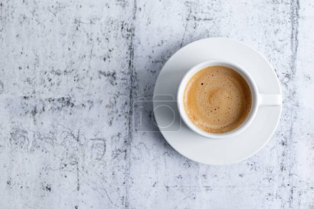 Photo for Espresso cup with coffee in white ceramic cup on grey background. Top View. - Royalty Free Image