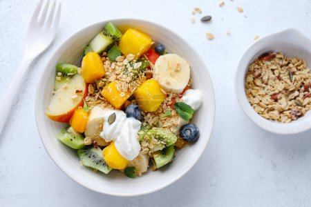 Foto de Muesli with fruits served in bowl on bright background. Healthy eating concept. - Imagen libre de derechos