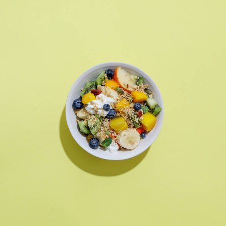 Foto de Muesli with fruits served in bowl on bright background. Healthy eating concept. Conceptual. - Imagen libre de derechos