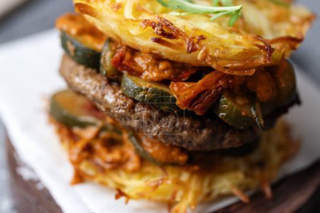 Foto de Healthy burger with beef, vegetables and potato patty. Closeup - Imagen libre de derechos