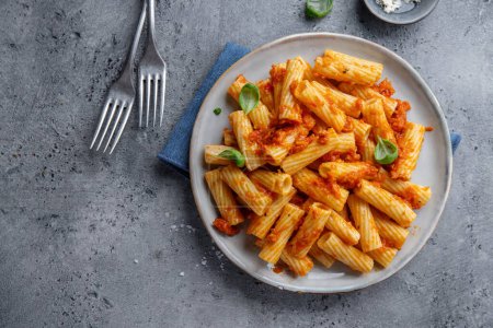 Téléchargez les photos : Pasta with tomato sauce chicken and basil served in bowl. Closeup - en image libre de droit