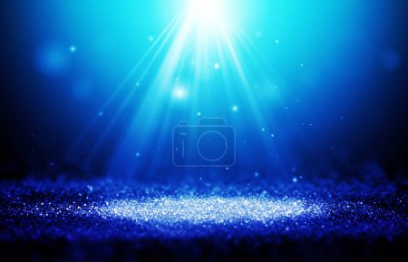 Téléchargez les photos : Rayons bleus scintillants lumières avec Spotlight bokeh spectacle élégant sur fond abstrait scène. Poussière étincelle arrière-plan.. - en image libre de droit