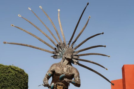 Téléchargez les photos : Statue d'un guerrier dansant de la Chichimeca / El Danzante Conchero Chichimeca dans le centre-ville de Queretaro, Mexique 2022 - en image libre de droit
