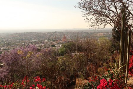 Foto de Vista desde un mirador a la ciudad de San Miguel de Allende con su famosa iglesia / catedral Parroquia de San Miguel Arcangel en el centro, México 2022 - Imagen libre de derechos