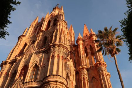 Foto de La hermosa fachada superior de la iglesia / catedral Parroquia de San Miguel Arcangel en San Miguel de Allende al atardecer, México 2022 - Imagen libre de derechos