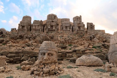 Die majestätischen Steinstatuen auf der Ostterrasse des Nemrut-Berges, Reihe von Götterkörpern auf Thronen im Hintergrund und Kopf des Zeus im Vordergrund, nahe Adiyaman, Türkei 2022