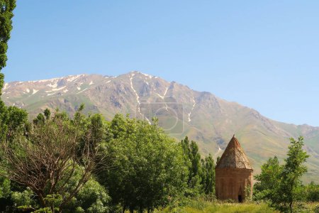 The Halime Hatun tomb, grave, mausoleum, Halime Hatun Kumbeti with the snow covered Mount Artos in the background and a little forest next to it, close to Lake Van, Van Golu, Gevas, Turkey 2022