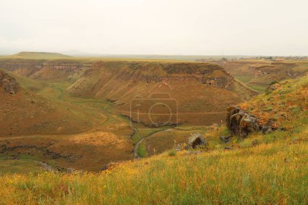 The Tsaghkotsadzor valley, gorge, canyon of the Alaca Cay river with man made caves next to the ancient site of Ani, an abandoned ruined armenian city, close to Kars, Turkey 2022