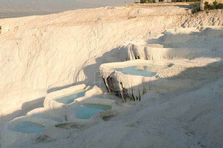 Closer look onto the travertine terraces of Pamukkale, filled with intense blue water, Denizli, Turkey 2022