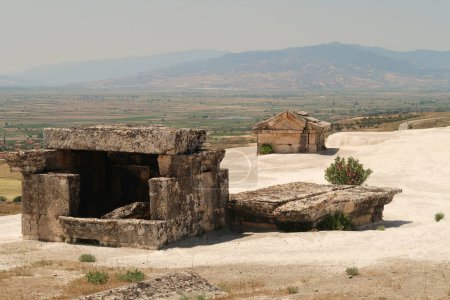 Tomb at the ancient site of Hierapolis sunken submerged in the limestone deposits of the travertines overlooking the valley, Pamukkale, Denizli, Turkey 2022