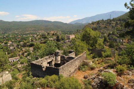 View on the abandoned village of Kayakoy, Livissi with a traditional house with chimney and without roof in the foreground, close to Fethiye, Turkey 2022