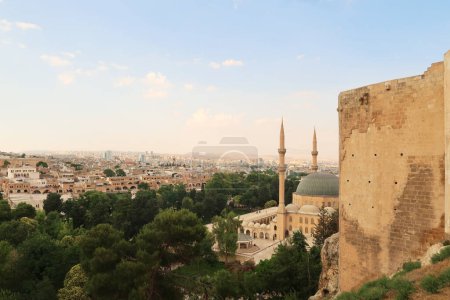 View from the hill of the Urfa Castle, Urfa Kalesi onto the Dergah Complex housing the Mevlidi Halil Camii Mosque and Abrahams Birth Cave and the city of Sanliurfa in the background, Sanliurfa, Turkey 2022