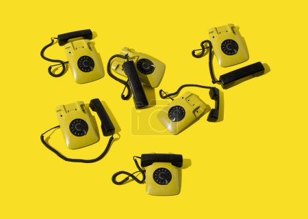 Photo for Retro yellow landline rotary telephones. Communication  background. - Royalty Free Image