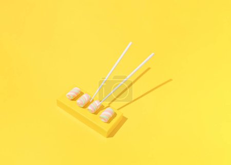 Foto de Colourful marshmallow candies served as sushi on yellow background.  Top view. - Imagen libre de derechos