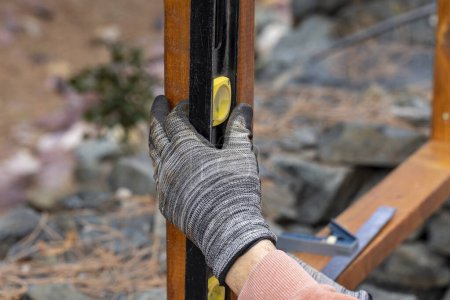 Téléchargez les photos : Panneaux de cèdre tachés utilisés pour construire une clôture horizontale par un entrepreneur à l'aide d'une perceuse à piles - en image libre de droit