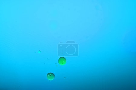 Photo for Oil and water do not mix, blue and green balls - Royalty Free Image