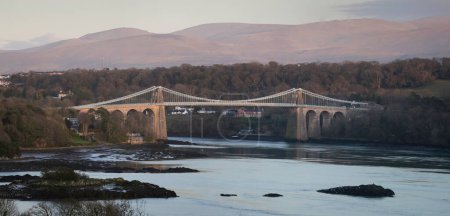 Téléchargez les photos : Le pont suspendu Menai enjambant le détroit de Menai qui sépare Anglesey du continent du nord-ouest du pays de Galles dans l'U - en image libre de droit