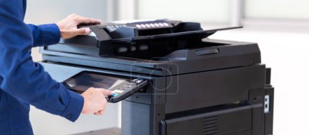 Photo for Businessman press button on panel of printer photocopier  network , Working on photocopies in the office concept , printer is office worker tool equipment for scanning and copy paper. - Royalty Free Image