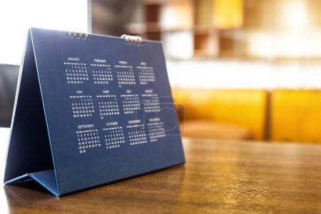 Téléchargez les photos : Calendrier page flipping sheet on wood table background business schedule planning meeting concept - en image libre de droit