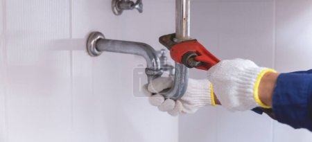 Téléchargez les photos : Plombier fixation tuyau d'évier blanc avec clé réglable. - en image libre de droit