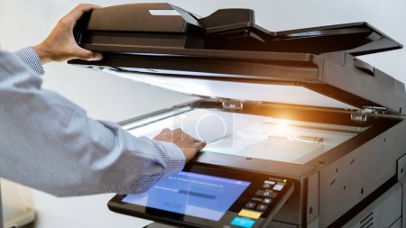 Téléchargez les photos : Homme d'affaires Appuyez sur le bouton de la main sur le panneau de l'imprimante, imprimante scanner laser machine de copie de bureau fournitures commencer - en image libre de droit