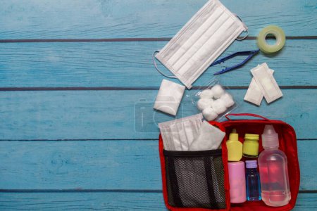 Foto de Vista superior bolsa de primeros auxilios niño con suministros médicos sobre fondo de madera. - Imagen libre de derechos