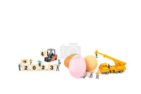 Photo for Miniature worker people and egg , isolated on white background - Royalty Free Image