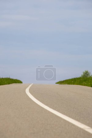 Téléchargez les photos : Route asphaltée avec herbe verte et ciel bleu en arrière-plan. - en image libre de droit