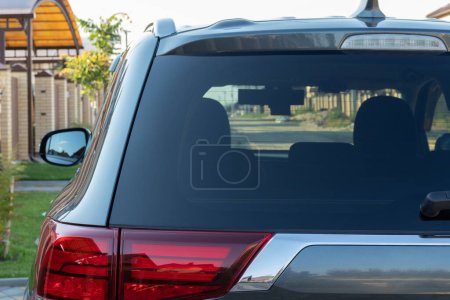 Photo for Car parked on the street in residential district, back view. Mock up of rear window for sticker or decals. - Royalty Free Image