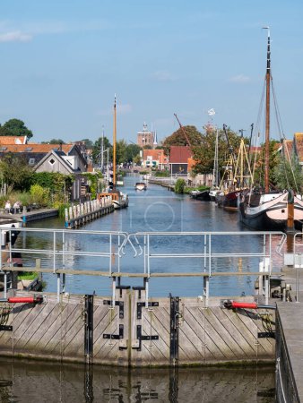 Photo for WORKUM, FRIESLAND - SEP 14, 2021: Diepe Dolte canal and church tower from locks in Workum, Friesland - Royalty Free Image