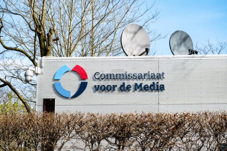 Téléchargez les photos : HILVERSUM, PAYS-BAS - 23 avril 2023 : Autorité néerlandaise des médias, nom et logo sur un bâtiment conçu par l'architecte Koen van Velsen avec des antennes paraboliques - en image libre de droit