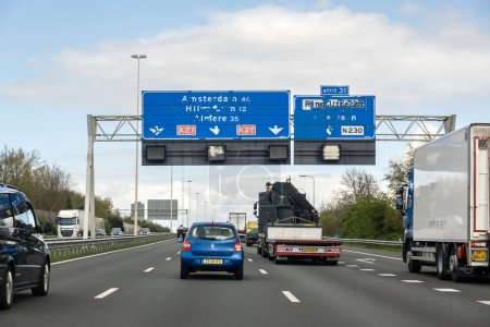 Photo for Traffic and unreadable direction signs on motorway A27 from Utrecht to Amsterdam - Royalty Free Image