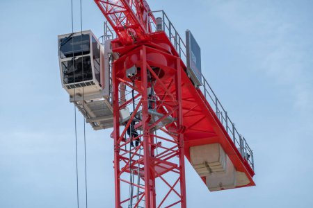 Téléchargez les photos : HILVERSUM, PAYS-BAS - 3 MAI 2023 : Détail de la grue à tour rouge avec flèche télescopique, escalier et cabine pour les travailleurs, Pays-Bas - en image libre de droit
