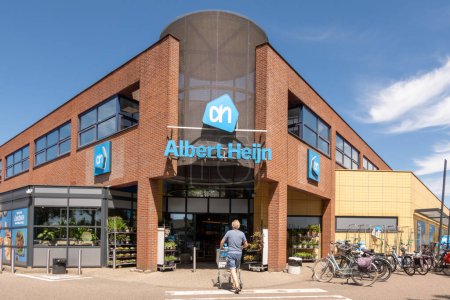 Téléchargez les photos : MEDEMBLIK, PAYS-BAS - 10 JUL 2023 : L'homme avec chariot fait ses courses chez Albert Heijn à Medemblik, la principale chaîne de supermarchés aux Pays-Bas - en image libre de droit