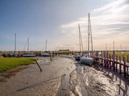 Sailboats in mud at low tide in harbour of Hooge hallig, North Frisian Islands, Schleswig-Holstein, Germany