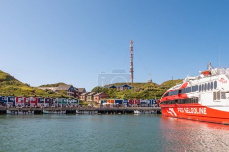 Foto de Helgoland, Alemania - 20 / 08 / 2023: Paseo marítimo y ferry en el puerto de Helgoland, isla en German Bight, Mar del Norte - Imagen libre de derechos