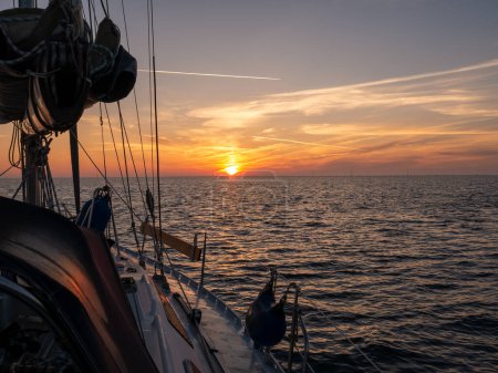 Sailing boat on Wadden Sea at sunrise, Sylt island, North Frisia, Schleswig-Holstein, Germany