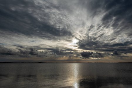 Panorama of Limfjord with the sun behind an impressive cloudscape, from Livo island, Nordjylland, Denmark