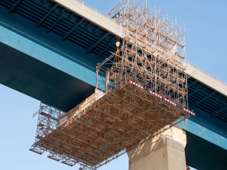 Scaffold construction with wooden planks under bridge over Kiel Canal, Germany, for safety during maintenance and repair work