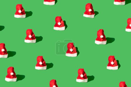 Foto de Santa Claus sombreros ayudante aislado en el patrón de fondo verde. Tema de celebración de Navidad y Año Nuevo - Imagen libre de derechos