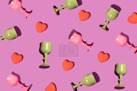Foto de Pattern made of hearts, pink and green wine glasses on a violet background. Valentines love concept - Imagen libre de derechos
