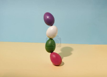Foto de Huevos de Pascua colocados en posición vertical sobre un fondo pastel. Concepto mínimo de vacaciones de Pascua. - Imagen libre de derechos