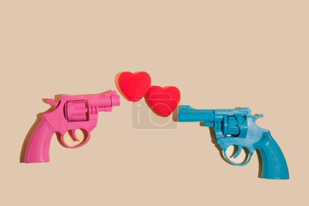 Foto de Creative valentines or romantic concept with pink and blue gun firing hearts on  yellow background. Minimal love concept. - Imagen libre de derechos