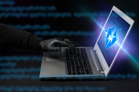Un cibercriminal rompiendo el sistema de seguridad de un portátil para estafar en línea. Peligro y alerta de phishing. Hacker estafa a través de páginas web