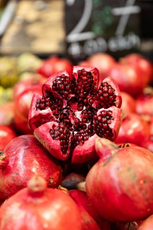Vibrant, ruby red cracked-open pomegranate at a market